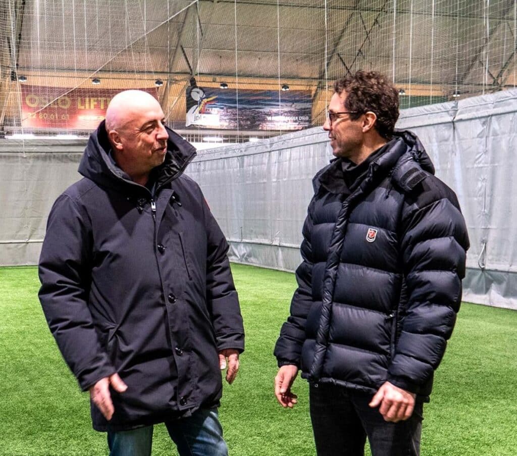 Per Einar Karlsen i Norsk Tipping og Freddy Dos Santos snakker med hverande ute p&aring; en stadion
